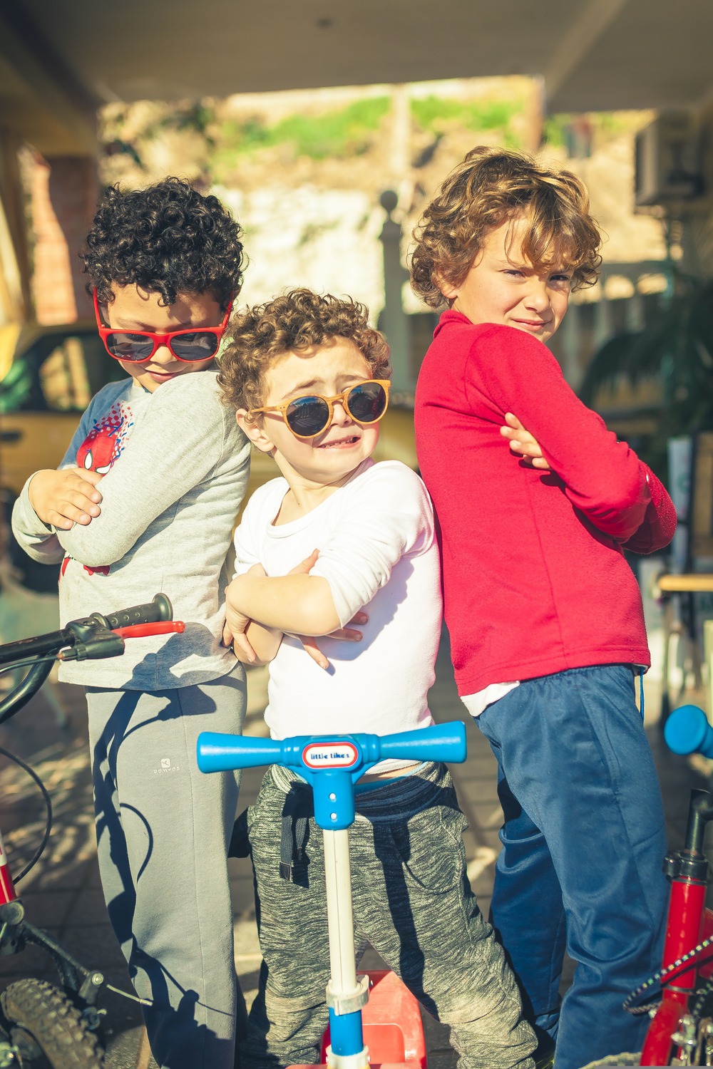 Trois enfants posant avec des trottinettes