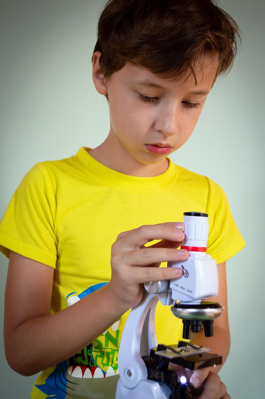 Enfant regardant &agrave; travers un miscroscope